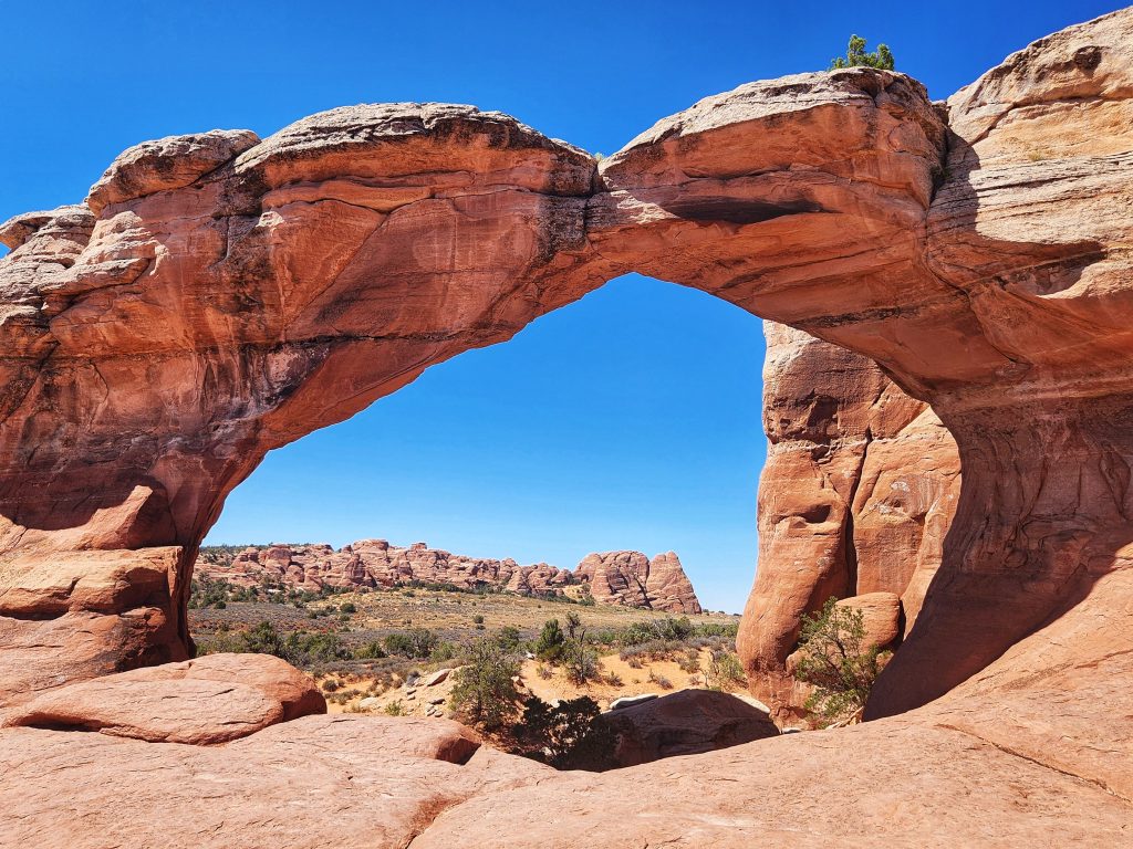 Arches National Park red rock desert landscape with natural sandstone arches under blue sky