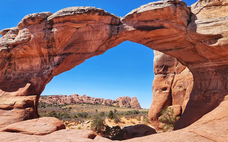 Arches National Park red rock desert landscape with natural sandstone arches under blue sky